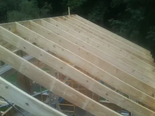 New roof rafters set over an addition before sheathing in Wampsville