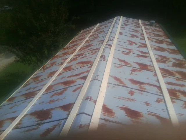 Rusted metal roof panels with new wood purlins before replacement — Storm Damage Roof Repair in Wampsville by Roofing Brothers