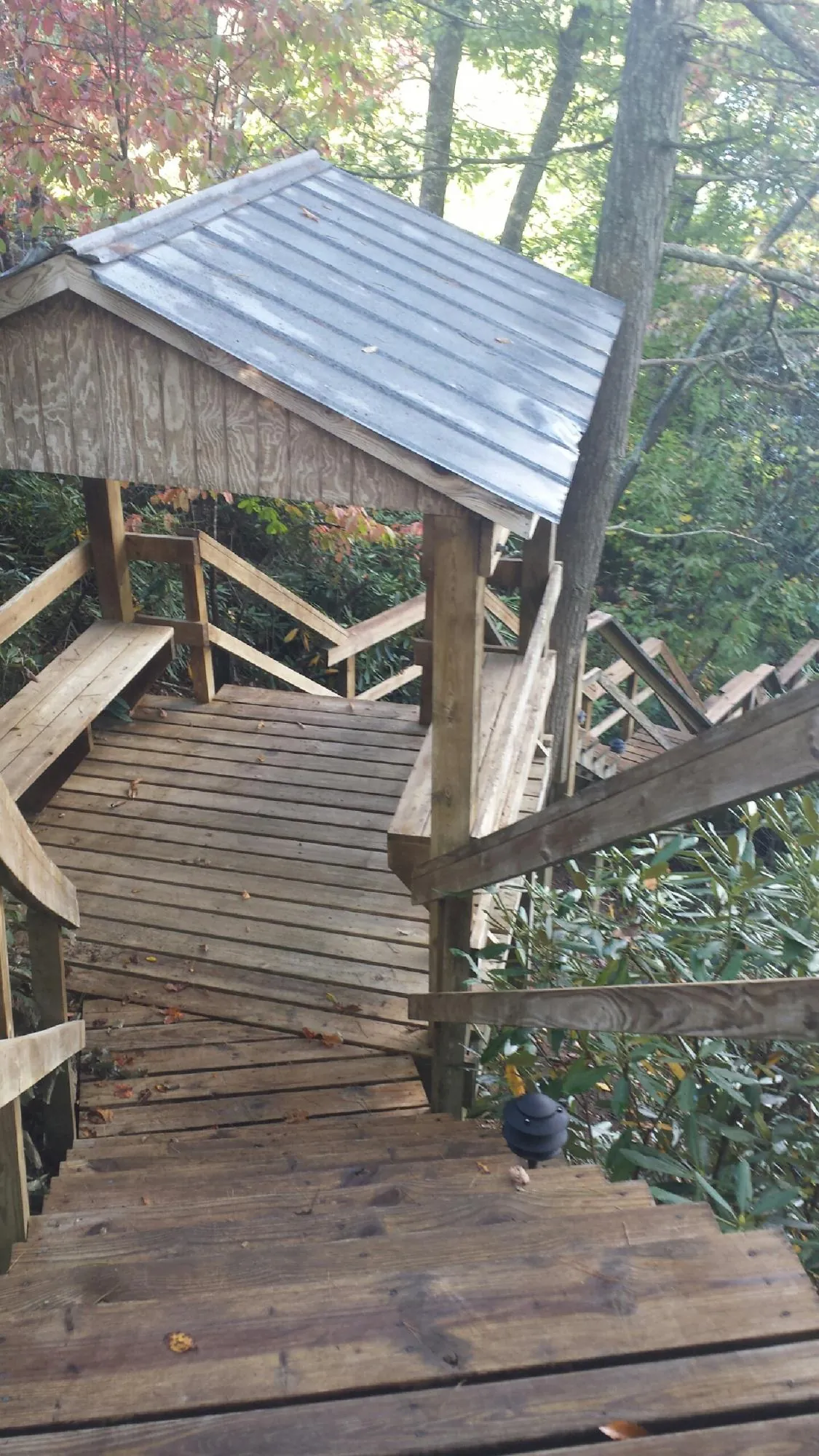 Metal roofed shelter over wooden steps on a wooded walkway — Skylight Repair & Installation work by our crew in Wampsville