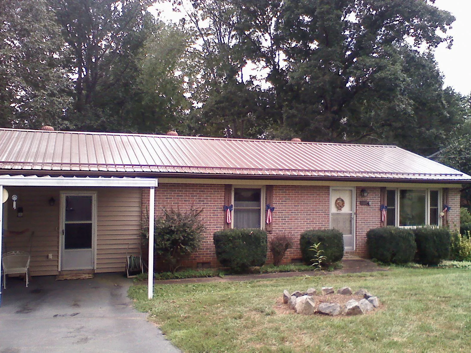Bronze metal roof and carport on a brick ranch home — Roof Repair work by our crew in Wampsville